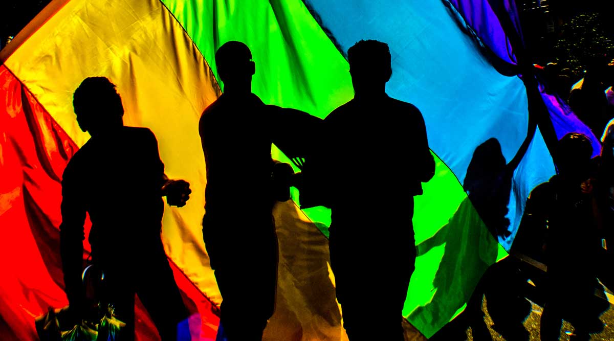 Silhouettes of People with a rainbow colored material behind them