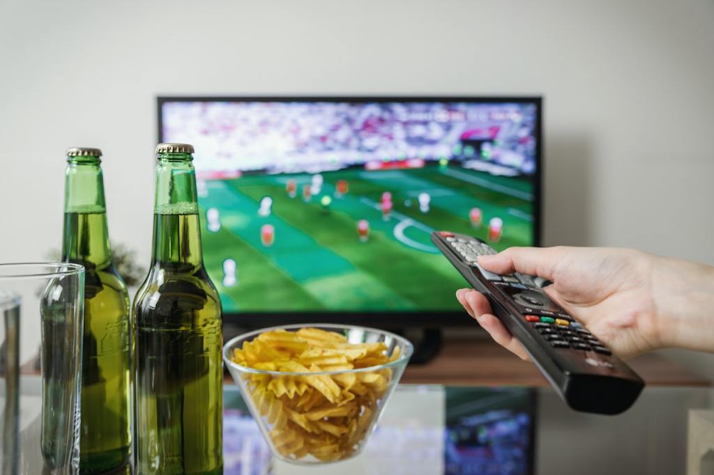 a hand holding a remote beginning to watch a World Cup game